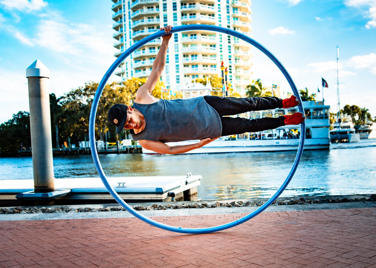 JP Singian practicing with a blue cyr wheel outdoors